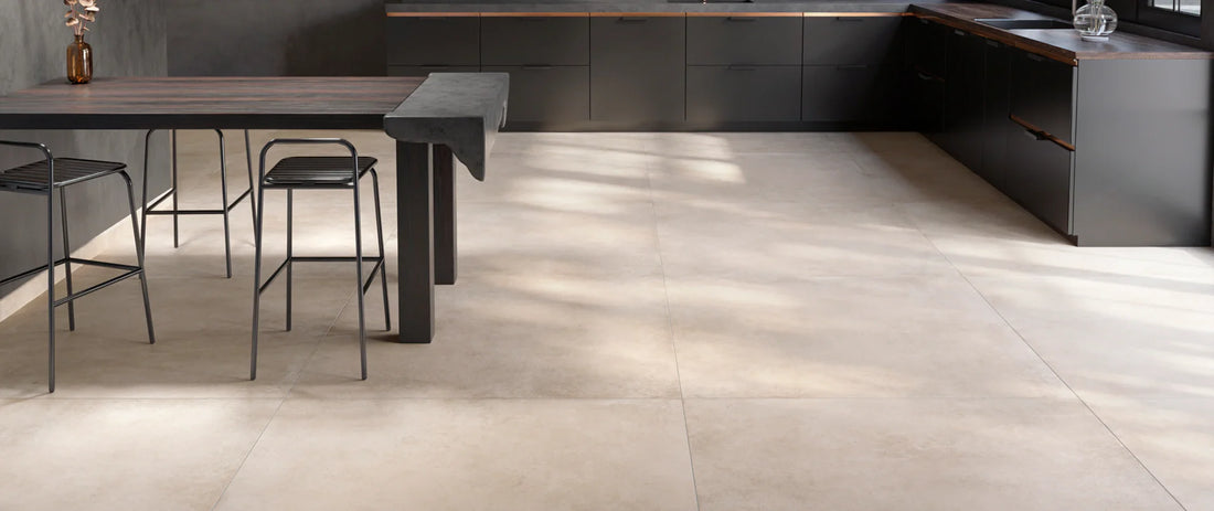 beige concrete-effect porcelain tile floor, 120x120 format, laid in a modern kitchen with dark units