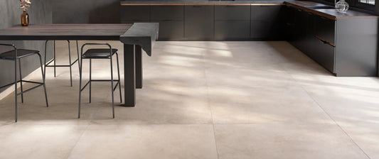 beige concrete-effect porcelain tile floor, 120x120 format, laid in a modern kitchen with dark units