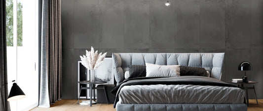 Modern bedroom with wood-effect porcelain tile flooring and 60×120 concrete-effect wall covering. 