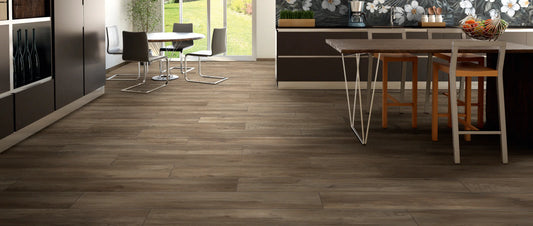 Realistic wood effect porcelain tiles in a warm brown oak shade, laid with a random offset and tone-on-tone grout in an open-plan kitchen