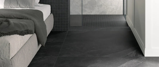 Stone effect porcelain tiles in a modern bedroom and bathroom with dark matte flooring