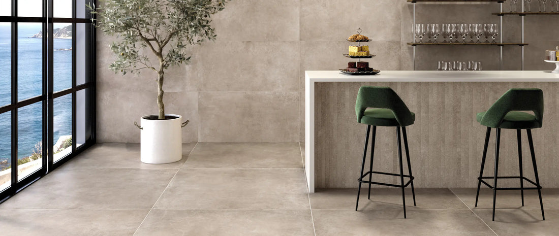 Taupe concrete-effect porcelain tiles in 120x120 and 60x120 formats covering floor and walls of a contemporary bar area