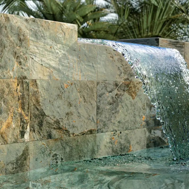 Outdoor wall covered with stone-effect porcelain stoneware tiles featuring a cascading waterfall and natural textures.