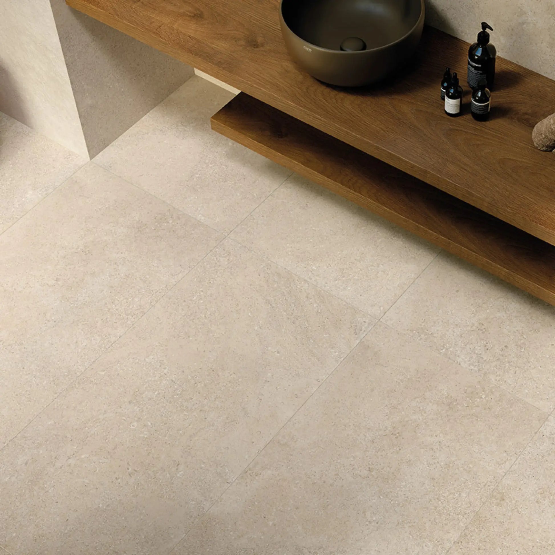 Bathroom interior top-view featuring beige stone-effect porcelain floor tiles, eterea sabbia