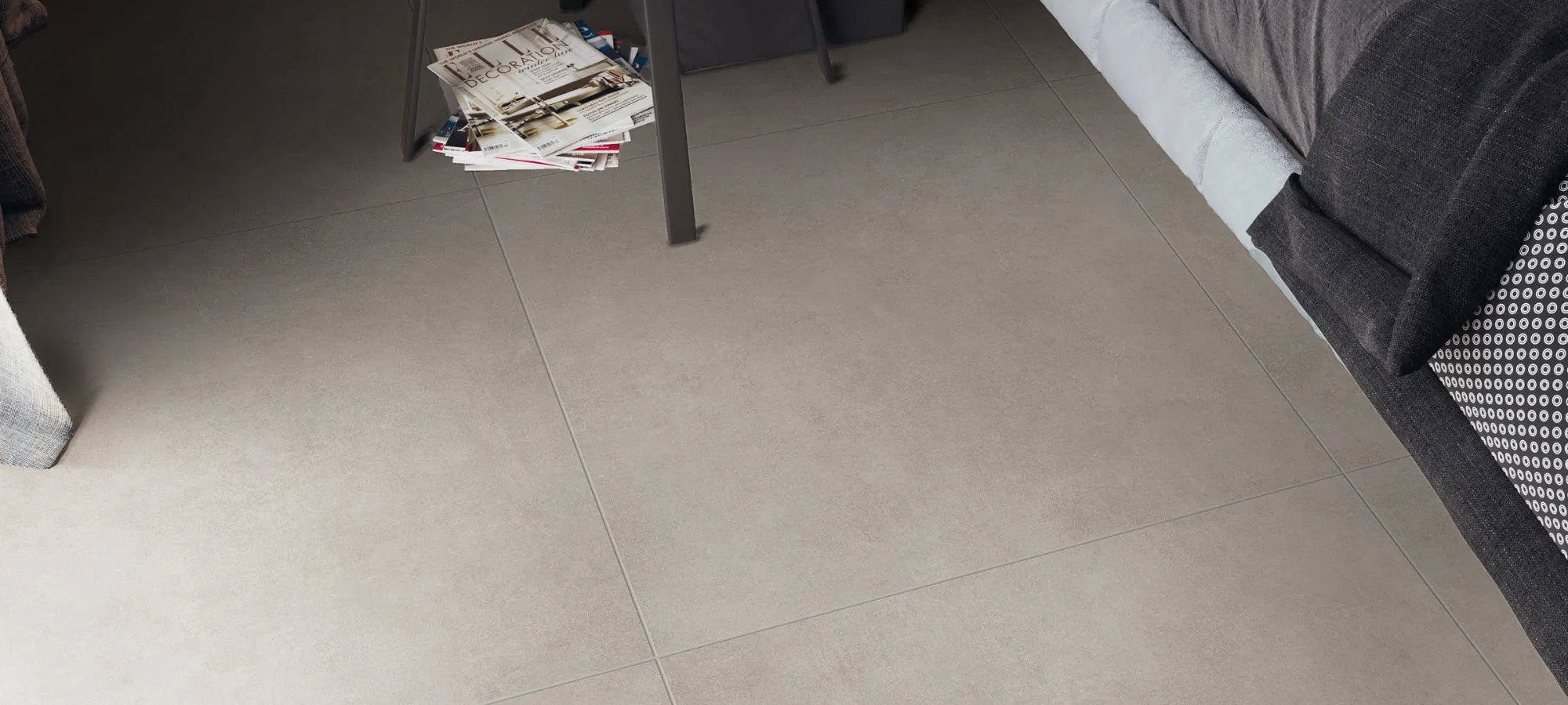 Concrete-effect porcelain stoneware floor tiles in a modern bedroom interior.