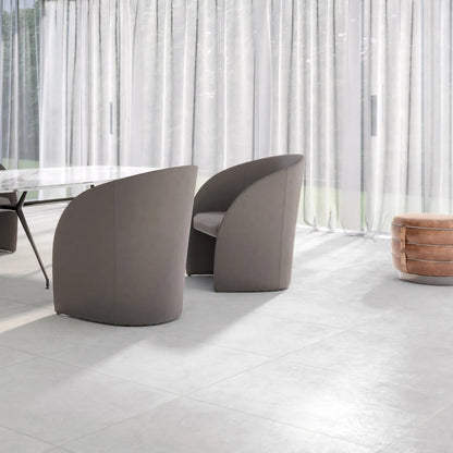 Light grey concrete-effect porcelain floor in modern dining room interior, le resine cenere