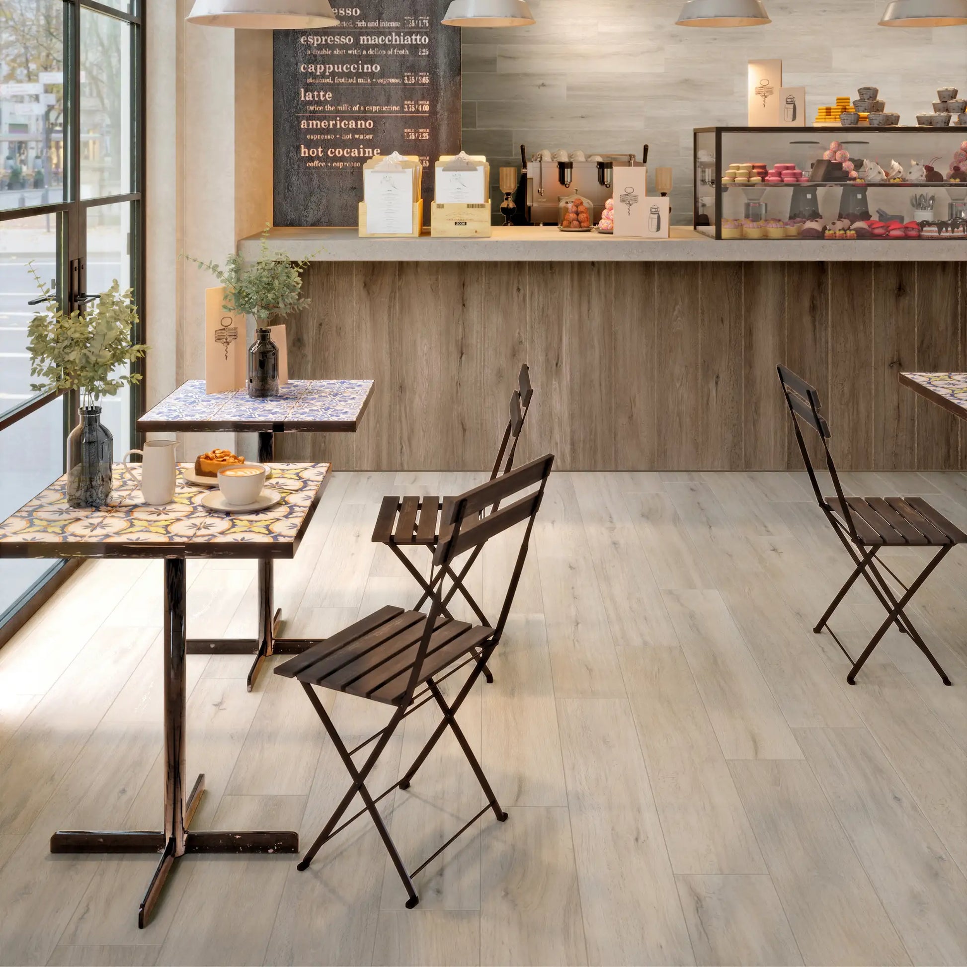 Light oak wood-effect porcelain tile flooring in a cozy café interior with natural warm tones - Firenze Sbiancato