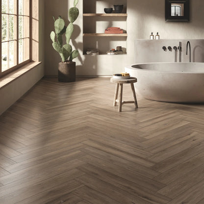Herringbone taupe oak wood-effect porcelain tile flooring in a warm modern bathroom - Firenze Tortora